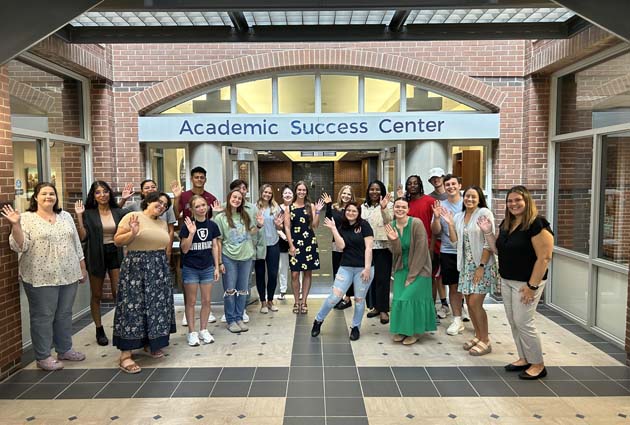 Students posing for photo in front of the Academic Success Center