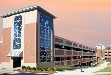 student walking in front of Shakespeare parking garage