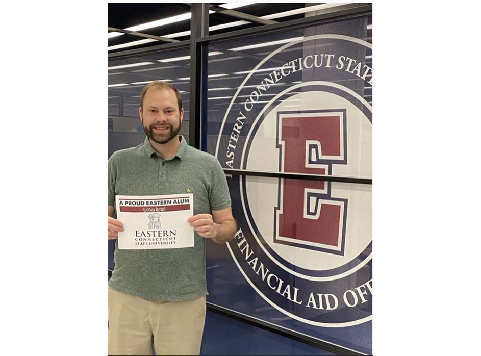 Dan, an alumni holding Eastern spirit poster